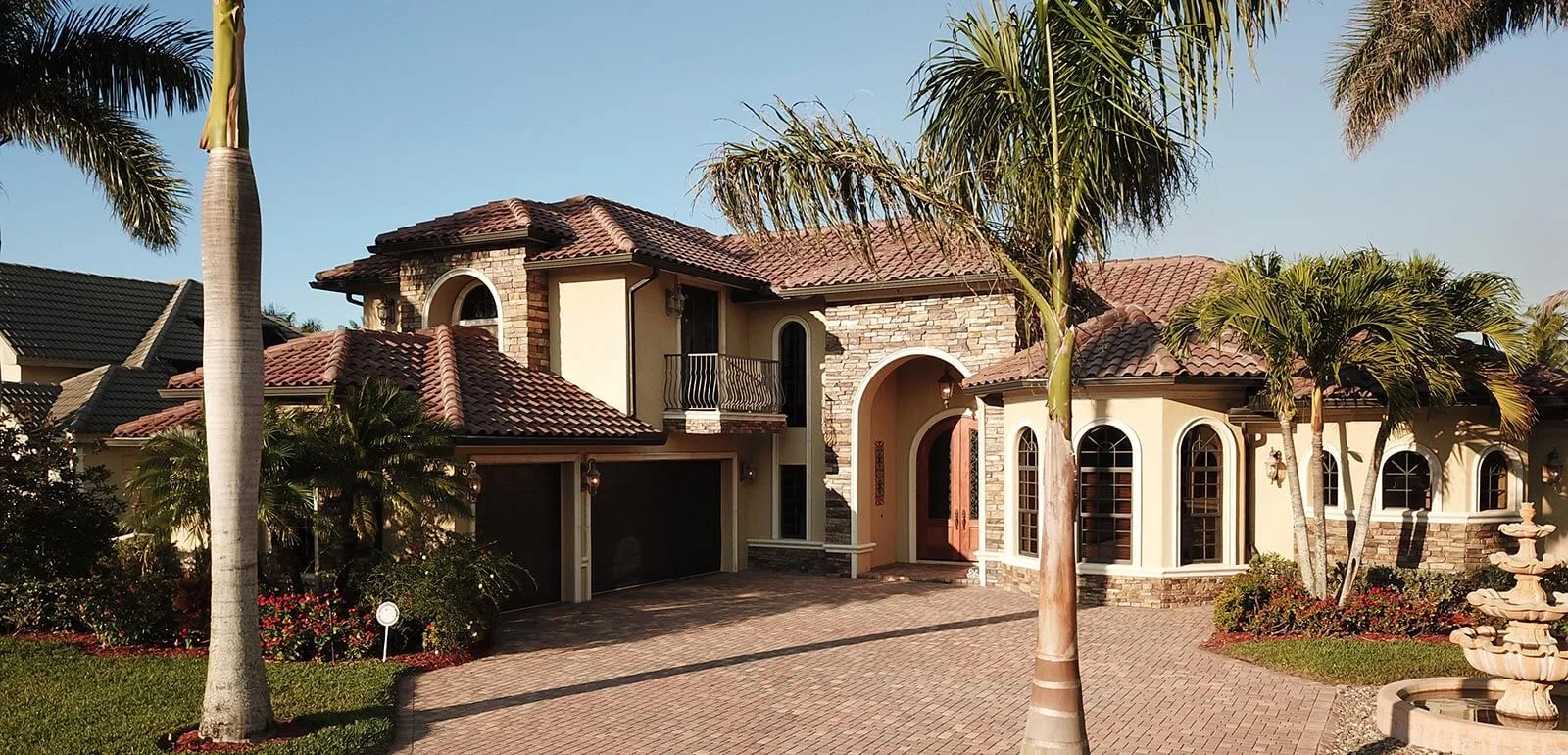 Tile roof on a Naples home with palm trees